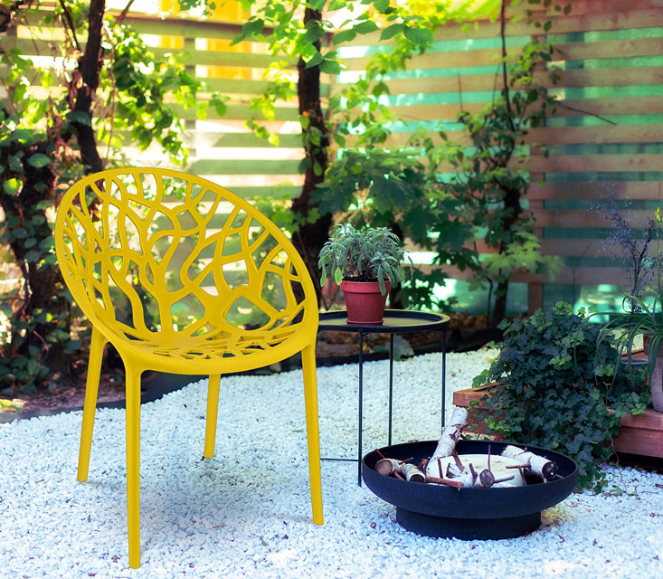Wykorzystanie żółtego krzesła ażurowego Moso we wnętrzu ogrodowym