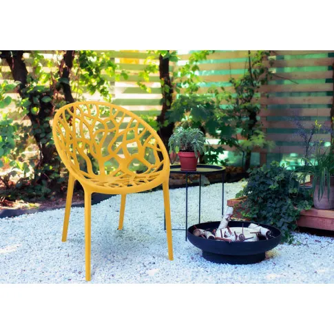 Ogród z wykorzystaniem ciemnożółtego krzesła ażurowego Moso