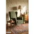 Zielony nowoczesny tapicerowany fotel uszak Snug w salonie vintage