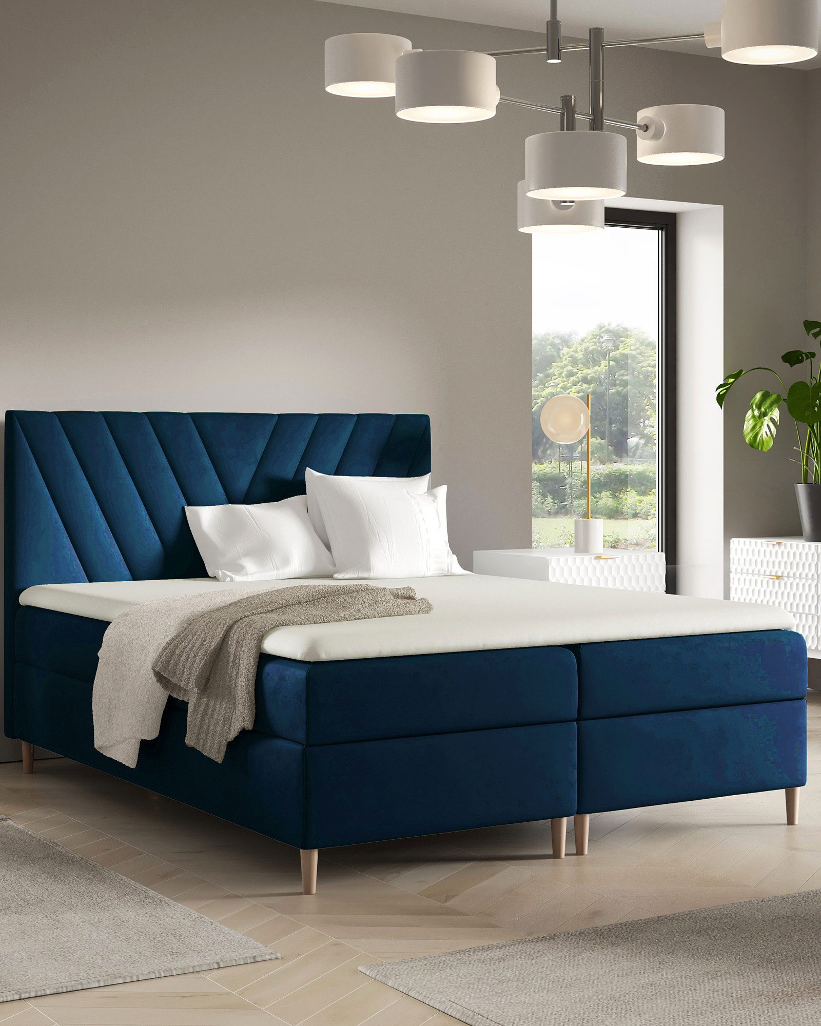 Aranżacja wnętrza z granatowym łóżkiem