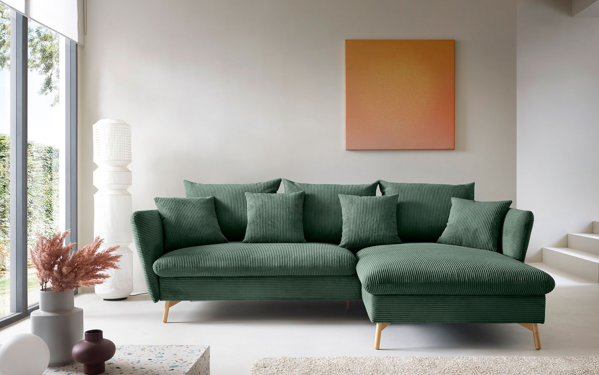 Salon z wykorzystaniem zielonego sztruksowego narożnika z funkcją spania Vettio