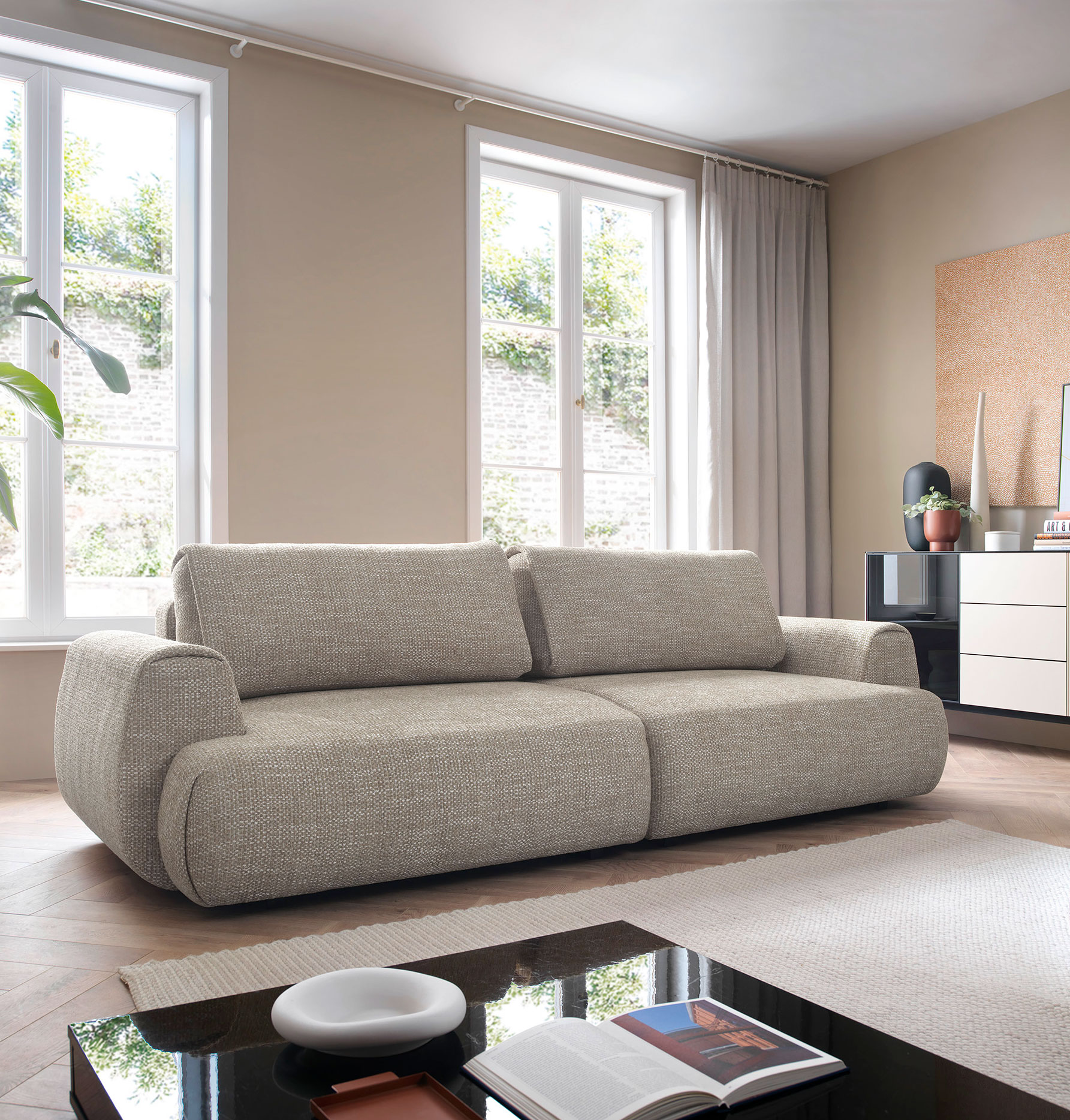 Rozkładana kanapa nowoczesna Evonis ciepły szary w nowoczesnym wnętrzu