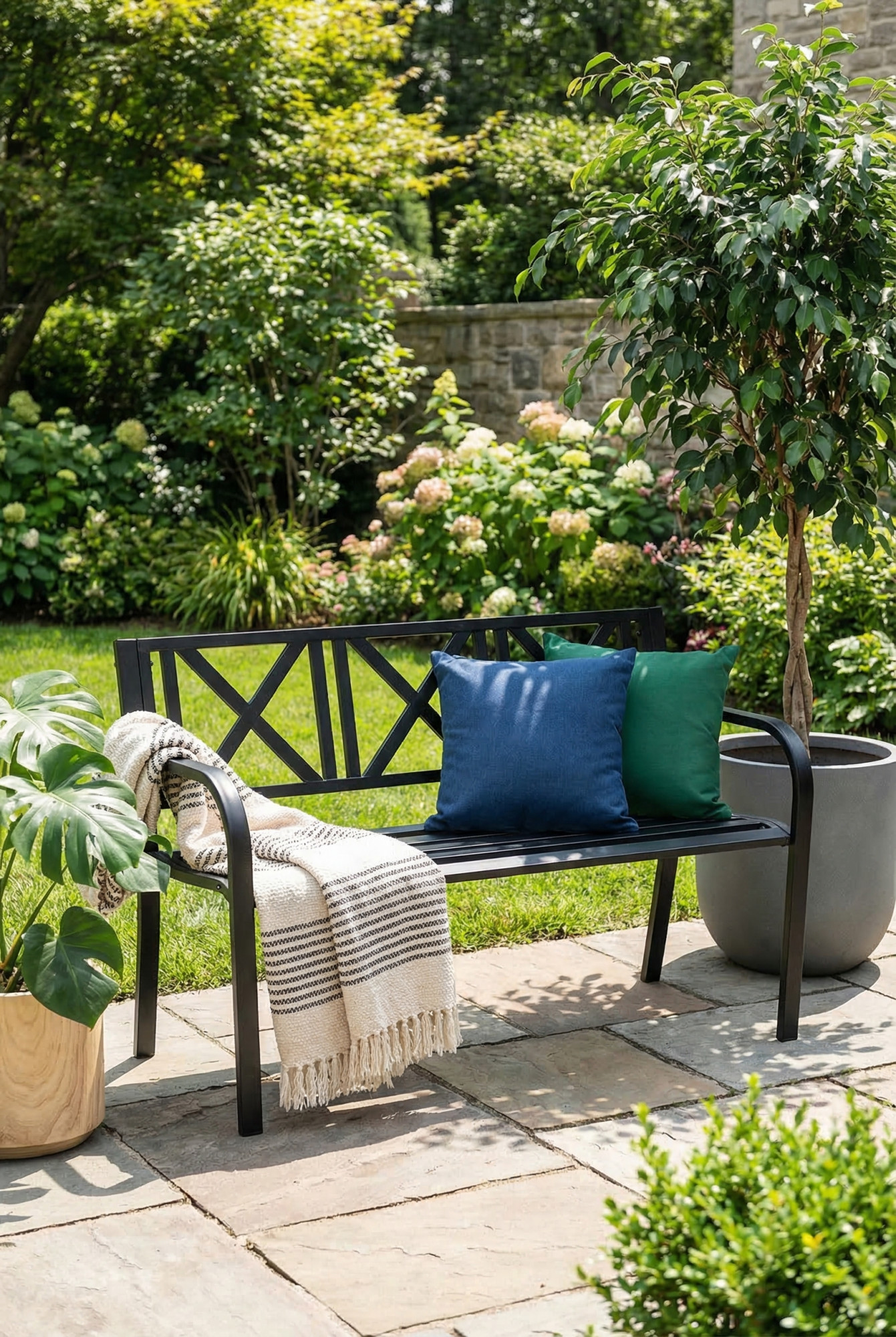 Ogród z wykorzystaniem czarnej metalowej ławki z oparciem Andizo 3X