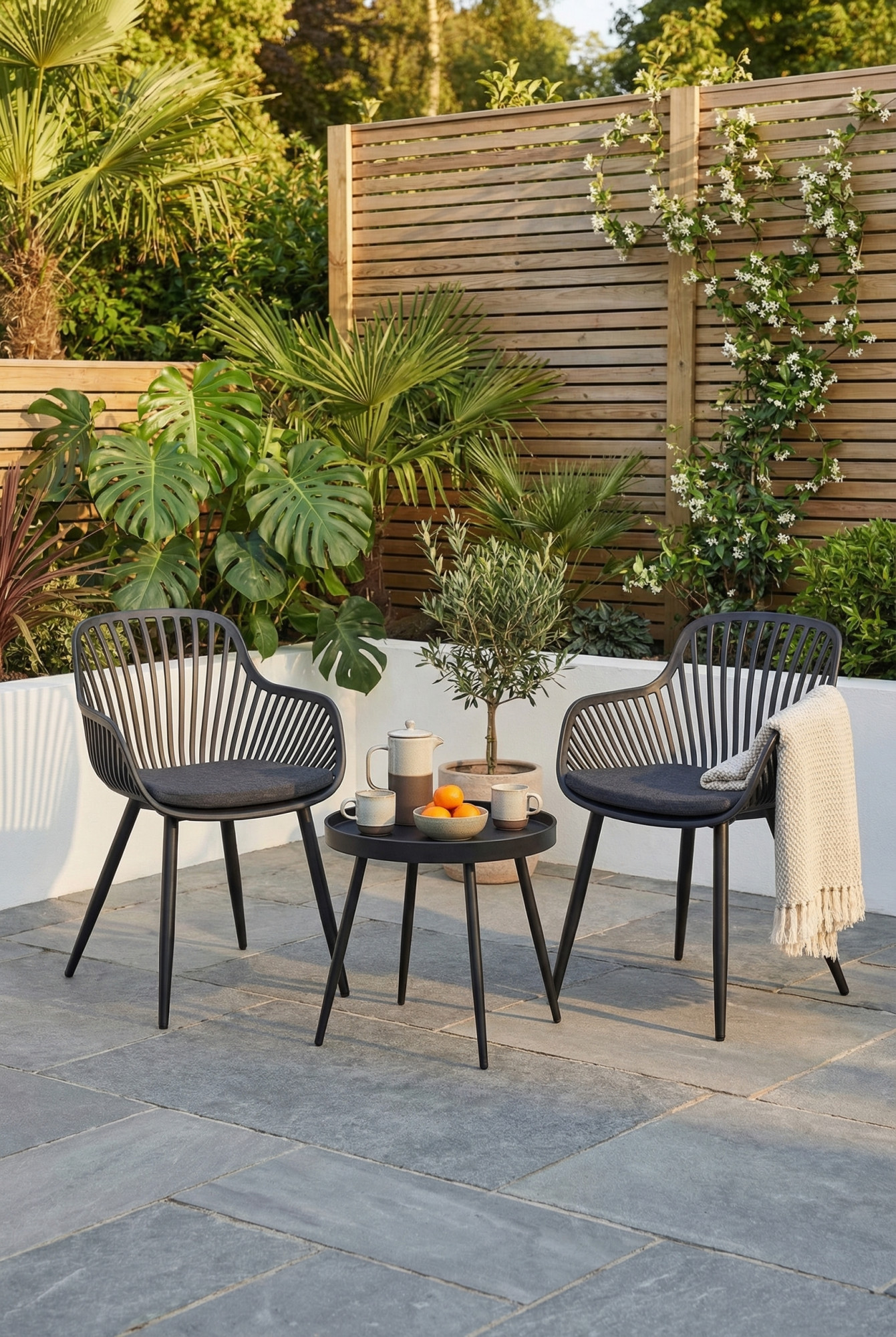Taras ogrodowy z czarnym zestawem mebli 3 krzesła i stolik kawowy Zationi